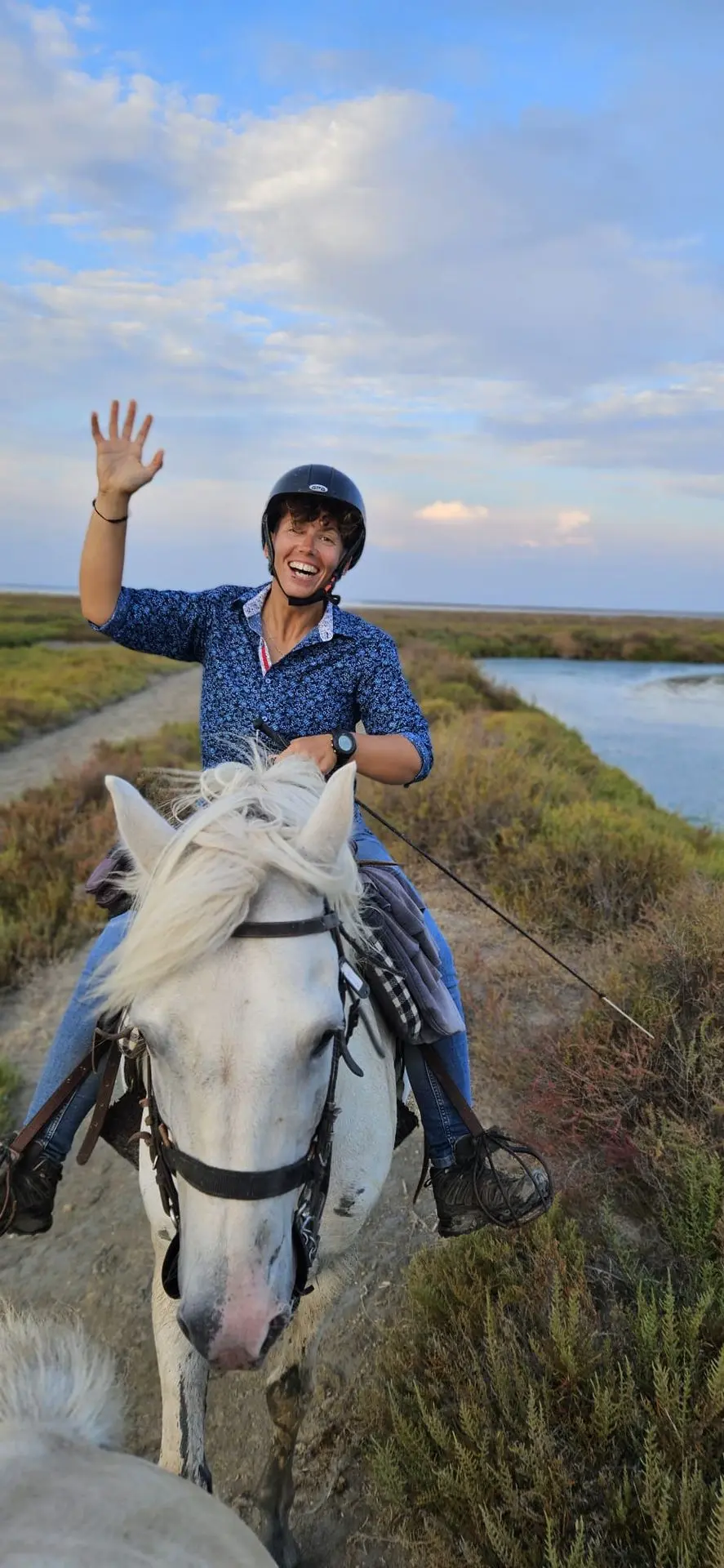 Un cavalier souriant saluant lors d'une promenade à cheval en Camargue avec La Fadaise, Saintes-Maries-de-la-Mer.